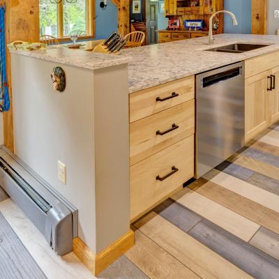 Modern kitchen view featuring a marble countertop, wooden cabinets, and multi-colored flooring.