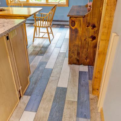 Interior view of a kitchen with patterned wood flooring and wooden furniture.