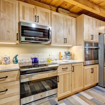 Modern kitchen with wooden cabinets, stainless appliances, and a light granite countertop.