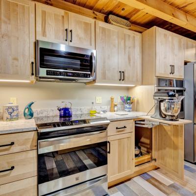 Modern kitchen with wooden cabinetry, stainless steel appliances, and a marble countertop.