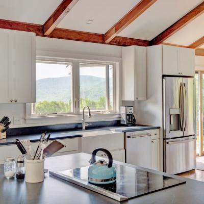 Bright kitchen with modern appliances and mountain view through the window.