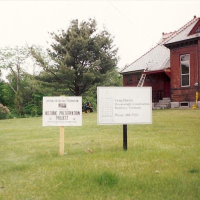 Historic preservation project signs in front of a house under construction.