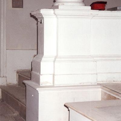Close-up of a white column base and steps in an interior setting.