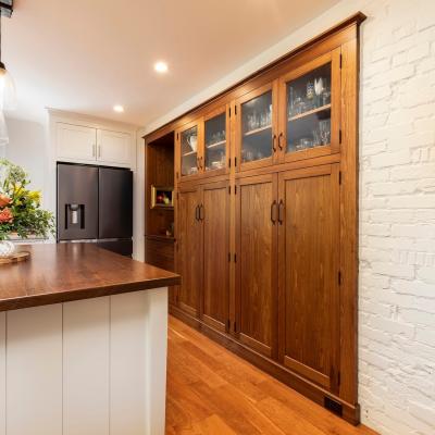 Modern kitchen featuring wooden cabinetry, a refrigerator, and vibrant floral decor.