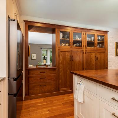 Modern kitchen with wood cabinetry, island, and floral centerpiece. Bright and inviting space.