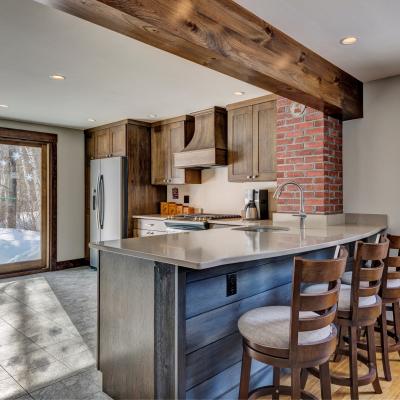 Modern kitchen with wooden cabinets, a brick accent wall, and a spacious island.
