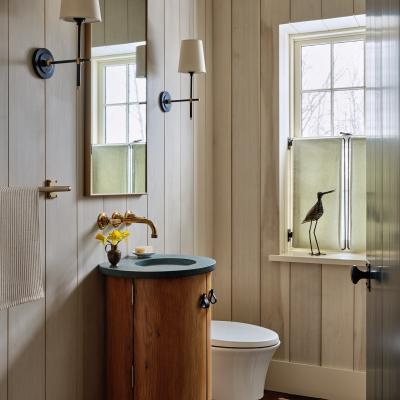 Modern bathroom with wooden accents, sink, mirror, and a decorative bird by the window.