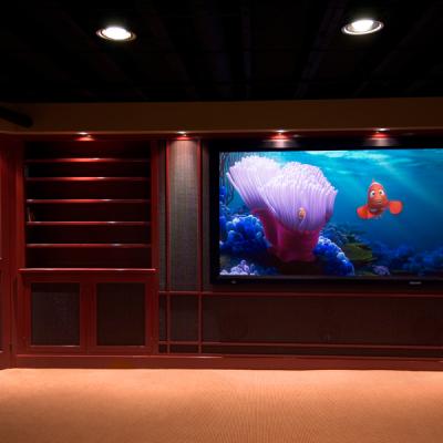 A home theater with a large screen displaying animated fish and coral.