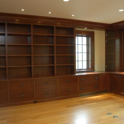 Wooden shelves and drawers in a bright, airy room with large windows.