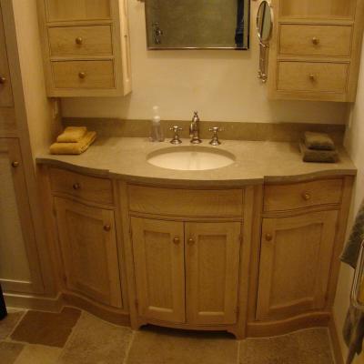 Modern bathroom with wooden cabinetry, a sink, and a mirror. Neat and well-organized.