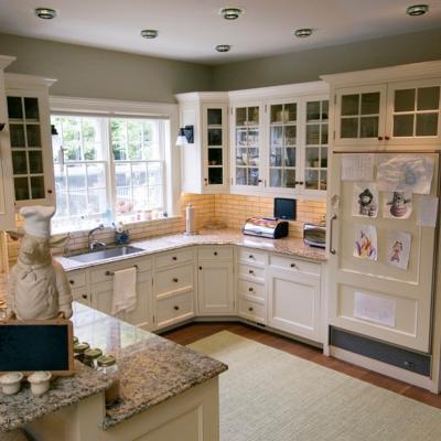 Bright kitchen with granite counters, white cabinets, and a chef pig statue.