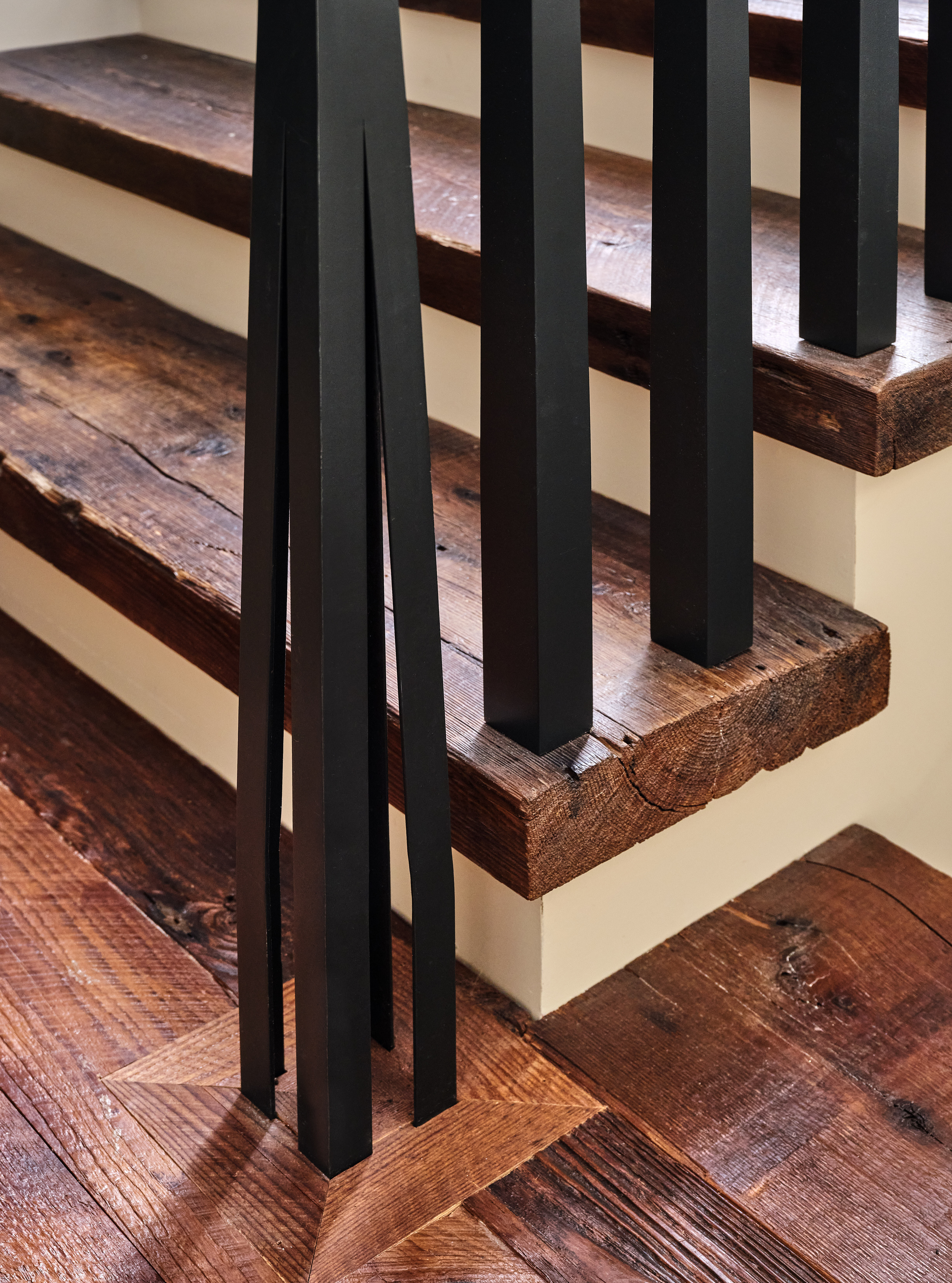 Modern staircase with black railings and rustic wooden steps.