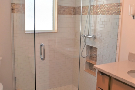 glass shower with white tile inside